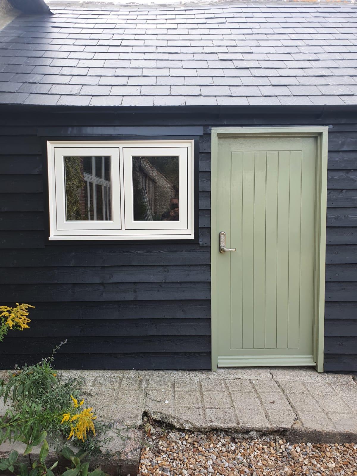 composite door and white frames on blue building