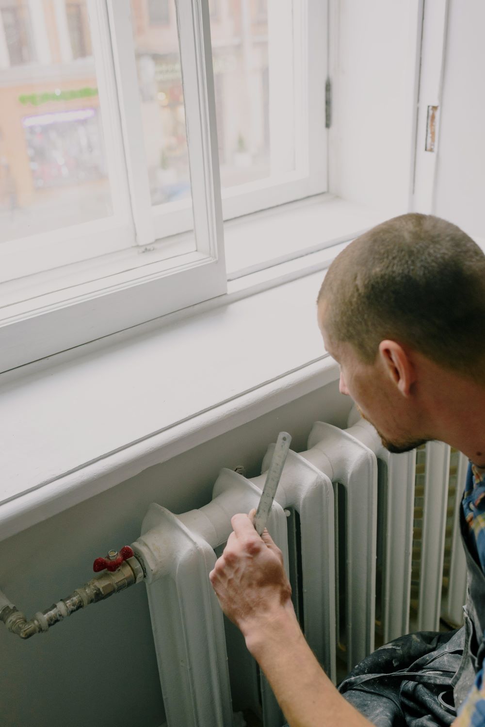 A person who identifies as a man bleeding a radiator. 