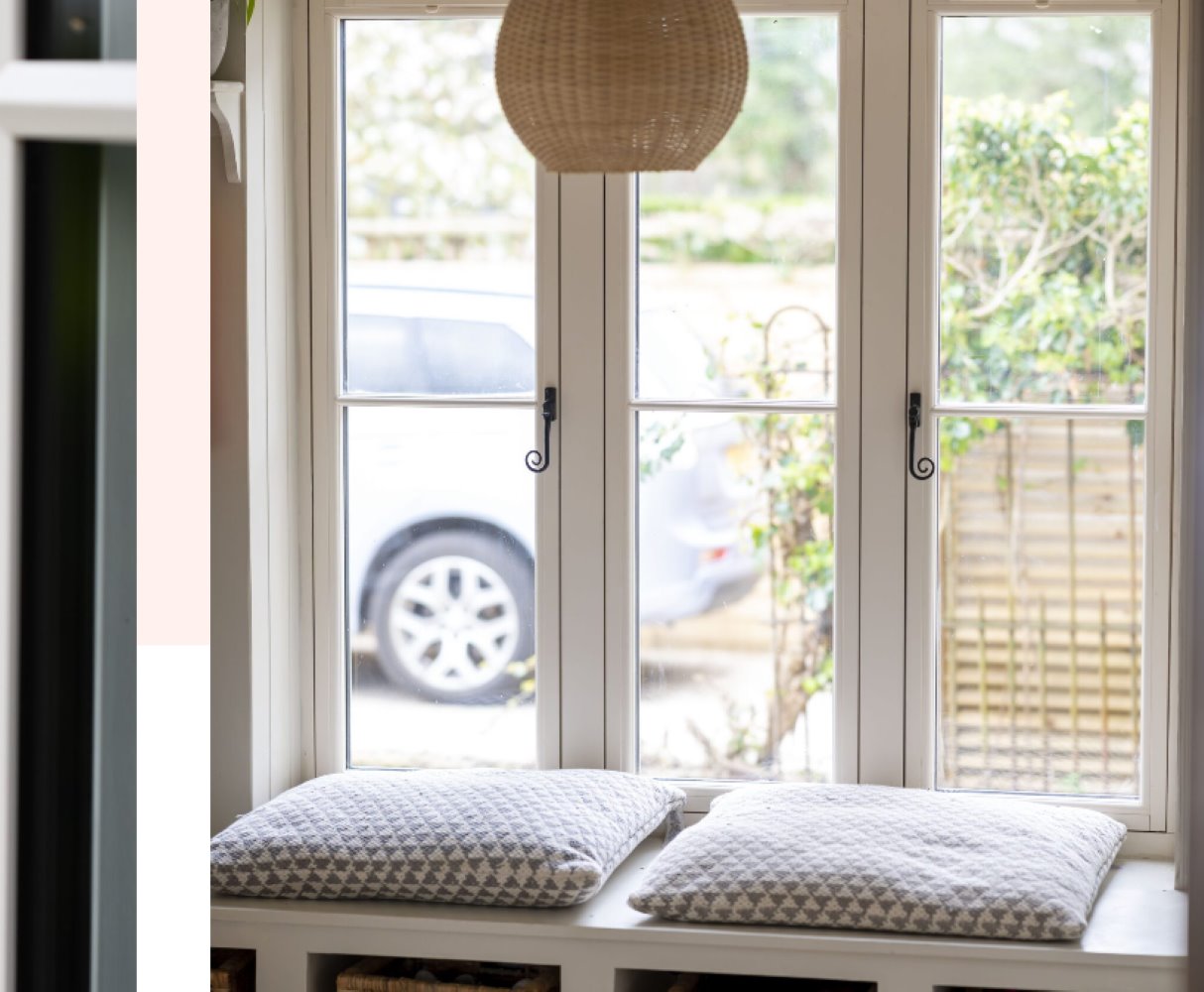 internal view of charming window seat featuring timber effect windows, decorative cushions, and stylish design
